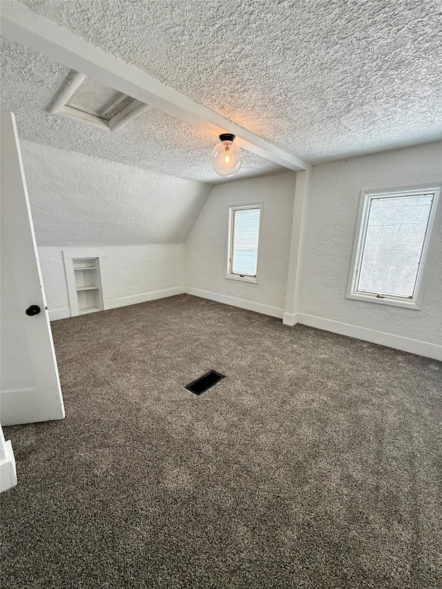 bonus room with a textured wall, carpet floors, a textured ceiling, baseboards, and lofted ceiling