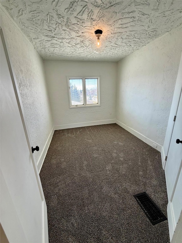 carpeted spare room featuring visible vents, a textured ceiling, a textured wall, and baseboards