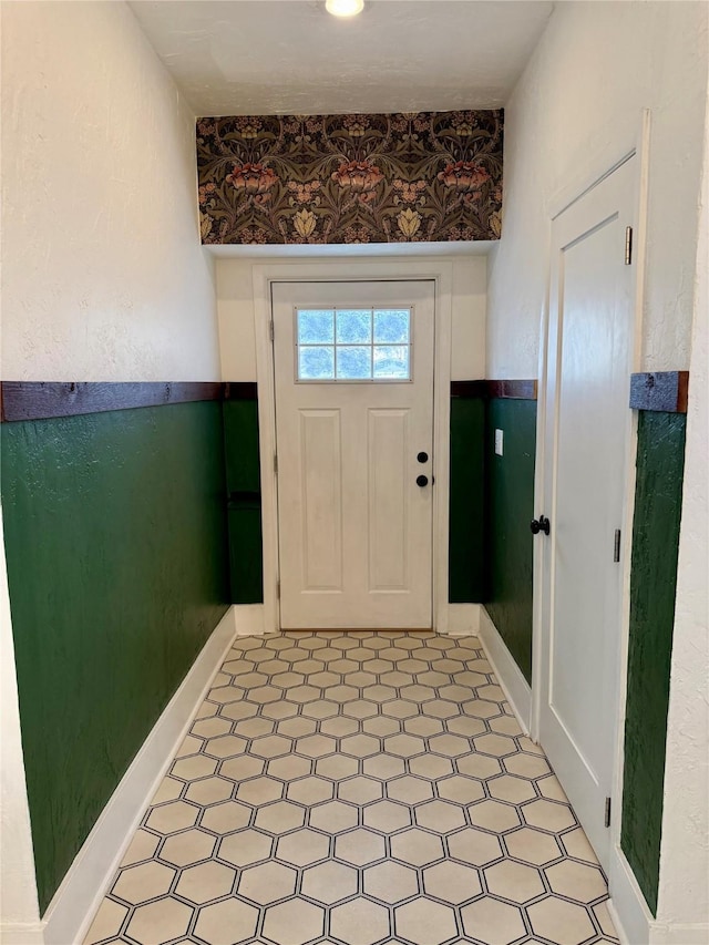 foyer entrance with baseboards and light floors