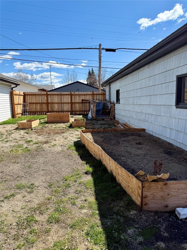 view of yard with fence and a garden