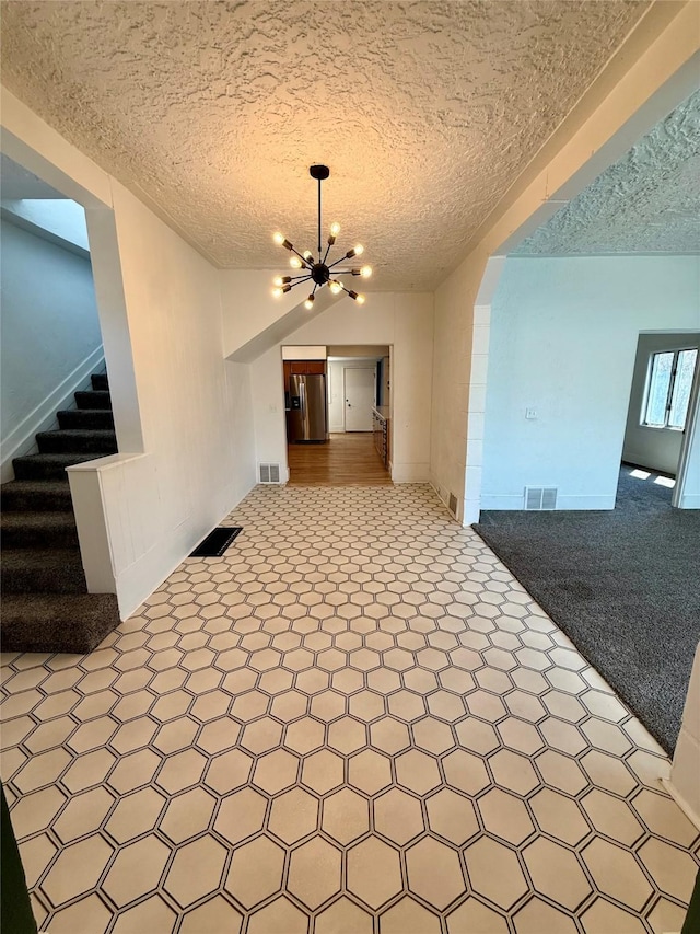 interior space with stairway, a chandelier, and visible vents