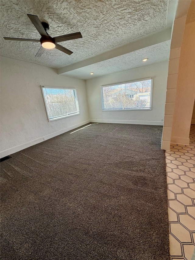 empty room featuring a ceiling fan, a textured ceiling, baseboards, and carpet