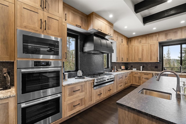 kitchen with recessed lighting, tasteful backsplash, a sink, dark wood finished floors, and appliances with stainless steel finishes
