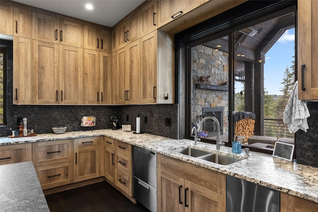 kitchen with stainless steel dishwasher, decorative backsplash, light stone countertops, dark wood-type flooring, and a sink
