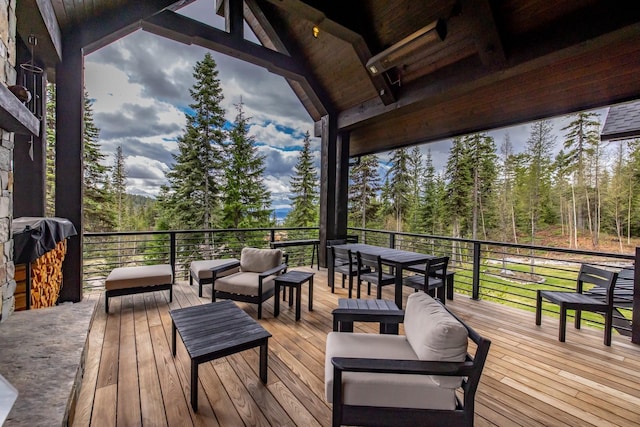 deck featuring outdoor lounge area and a forest view