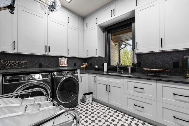 laundry area featuring cabinet space, separate washer and dryer, and a sink