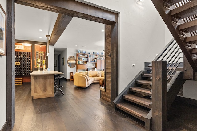 staircase featuring beamed ceiling, recessed lighting, baseboards, and wood finished floors