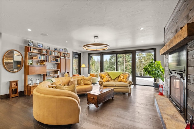 living room with dark wood-style flooring, a fireplace, baseboards, recessed lighting, and a textured ceiling