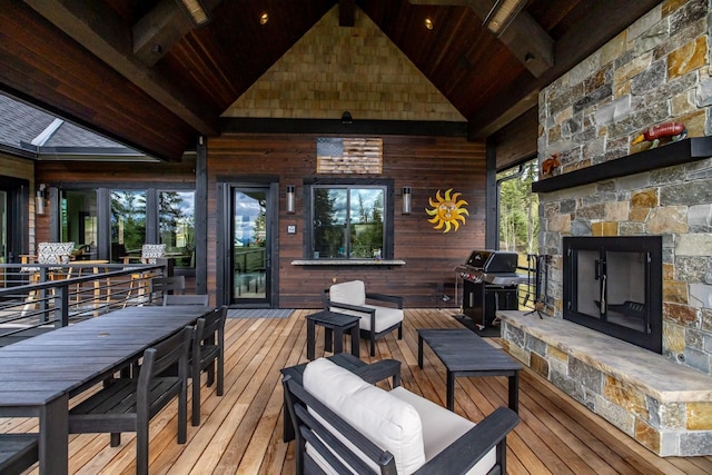 wooden deck featuring area for grilling and an outdoor stone fireplace
