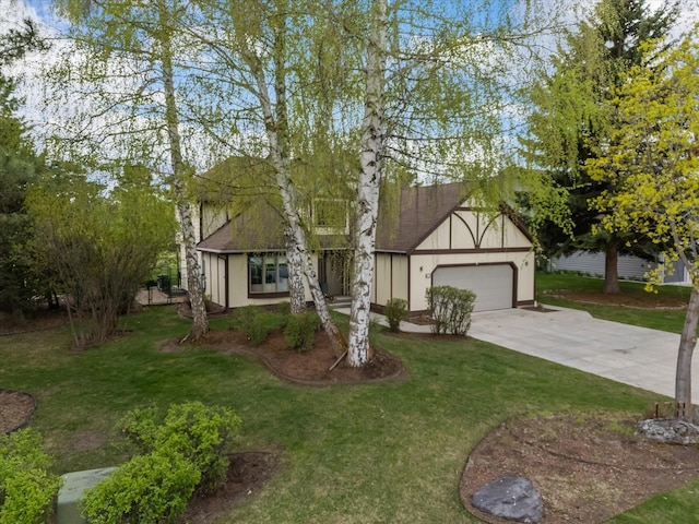 128 River View Dr, Kalispell, MT 59901 - tudor home featuring concrete driveway, a front lawn, and a garage