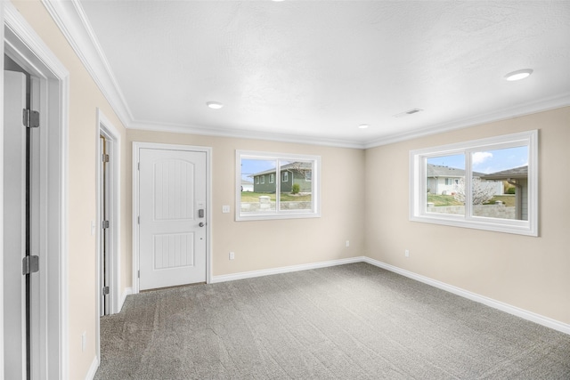 carpeted empty room with baseboards, ornamental molding, and visible vents
