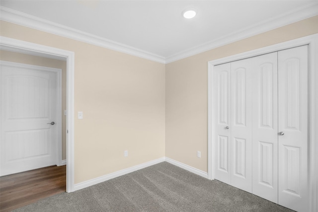 unfurnished bedroom with baseboards, ornamental molding, a closet, and carpet floors