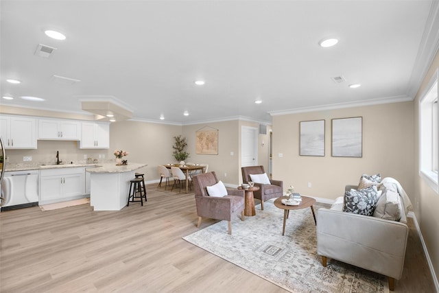 living area with crown molding, recessed lighting, baseboards, and light wood finished floors