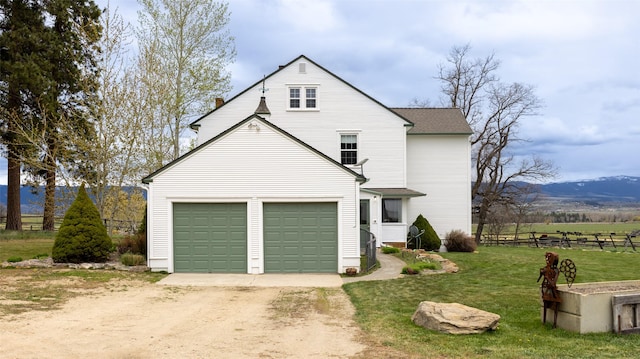 exterior space with fence, a shingled roof, a garage, a yard, and driveway