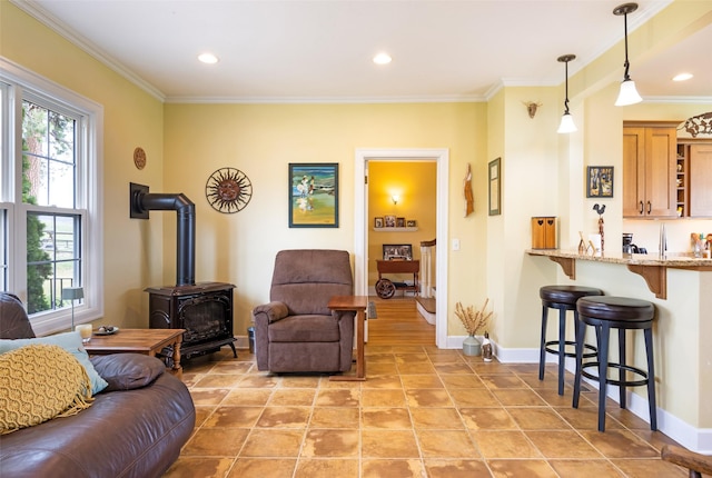 living area with crown molding, baseboards, and a wood stove