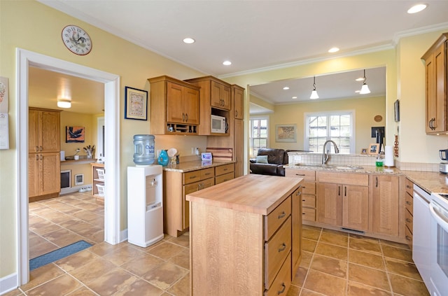 kitchen featuring a center island, a peninsula, wood counters, ornamental molding, and white appliances