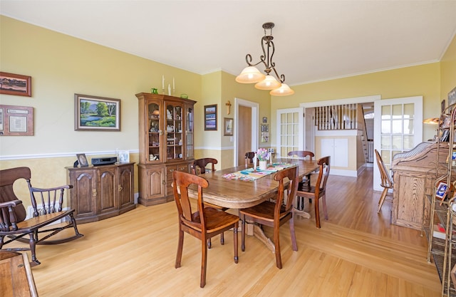 dining room featuring crown molding and light wood-style flooring