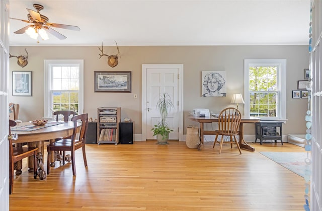 dining area featuring ornamental molding, a healthy amount of sunlight, and light wood-style flooring