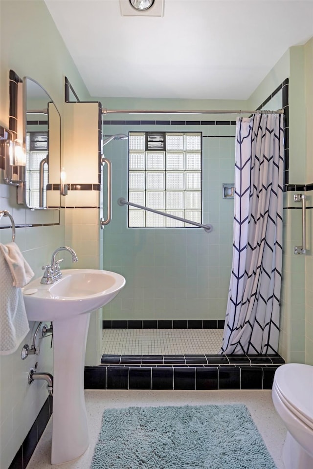 bathroom featuring a shower stall, toilet, and speckled floor