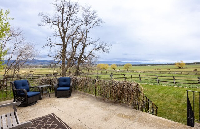view of patio featuring fence and a rural view