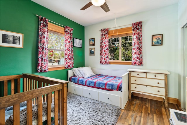 bedroom featuring ceiling fan, multiple windows, and hardwood / wood-style flooring