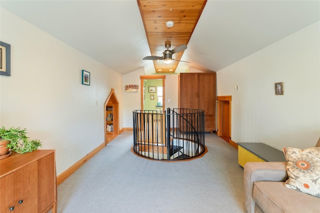 interior space featuring baseboards, ceiling fan, light carpet, and an upstairs landing
