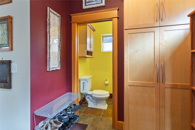 bathroom with baseboards and toilet