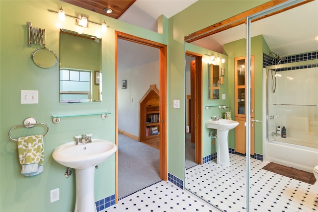full bathroom with baseboards, a sink, tile patterned floors, and bath / shower combo with glass door