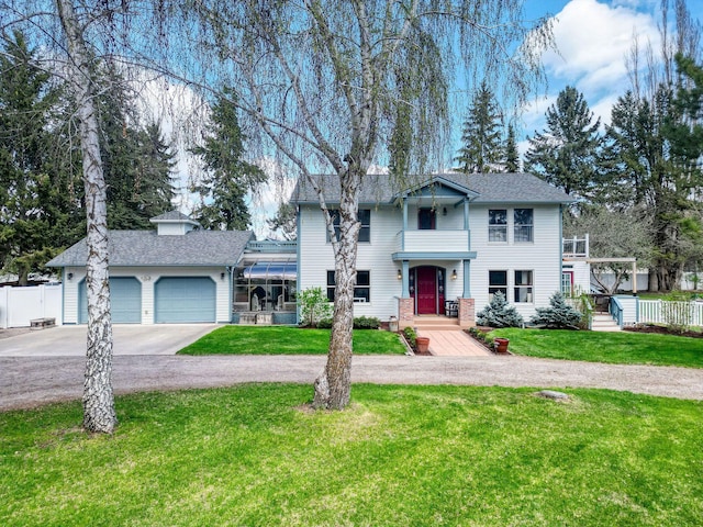 view of front facade with an attached garage, fence, a front yard, and concrete driveway