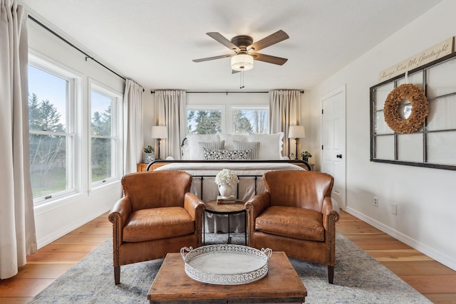 living area featuring baseboards, a wealth of natural light, and ceiling fan