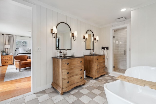 ensuite bathroom featuring crown molding, ensuite bath, vanity, a shower stall, and a soaking tub