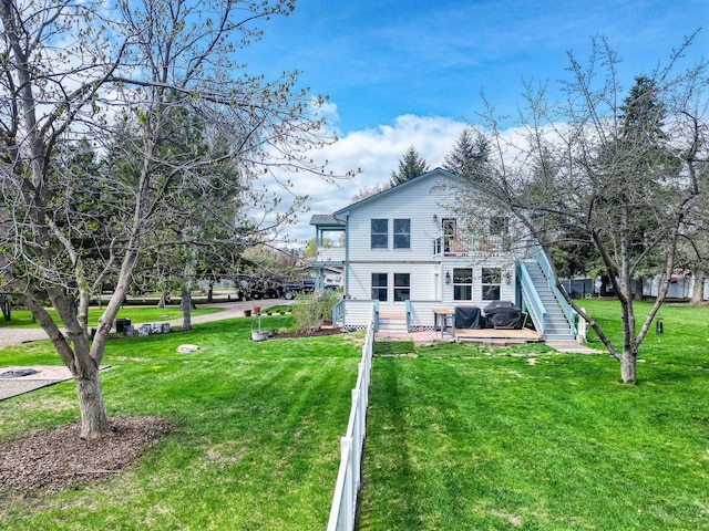 back of property featuring a lawn and a deck
