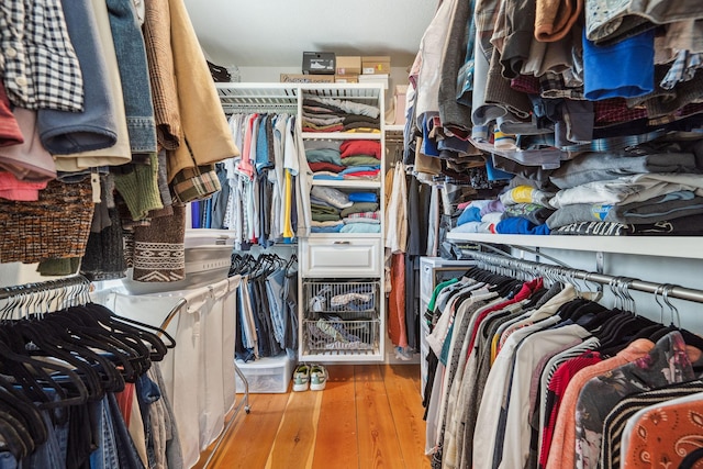 walk in closet with wood finished floors