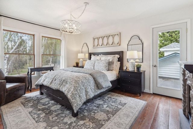 bedroom featuring an inviting chandelier, baseboards, and wood-type flooring