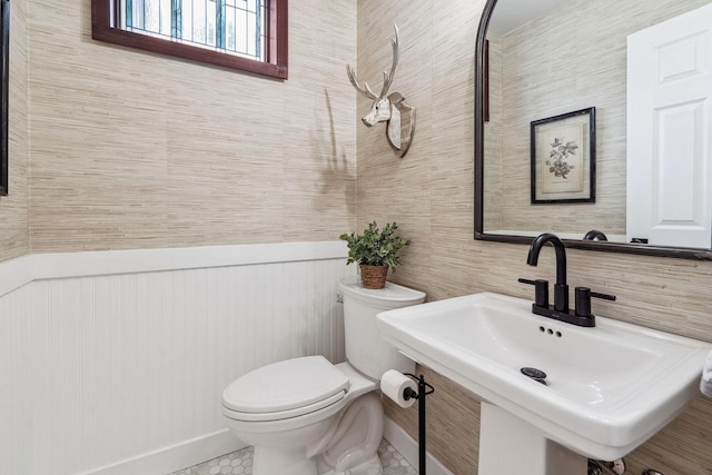 bathroom with baseboards, a sink, and toilet