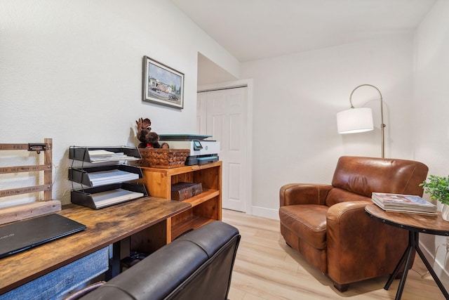 living area featuring light wood-style floors and baseboards