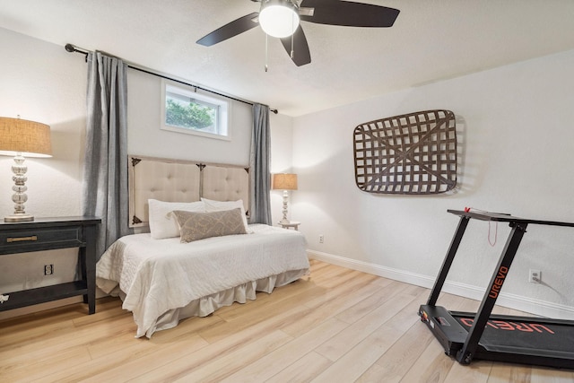 bedroom with a ceiling fan, baseboards, and wood finished floors