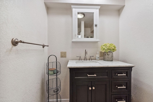 bathroom featuring vanity and a textured wall