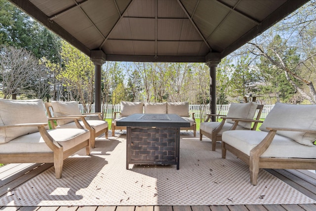 view of patio / terrace featuring a gazebo, fence, and an outdoor living space with a fire pit