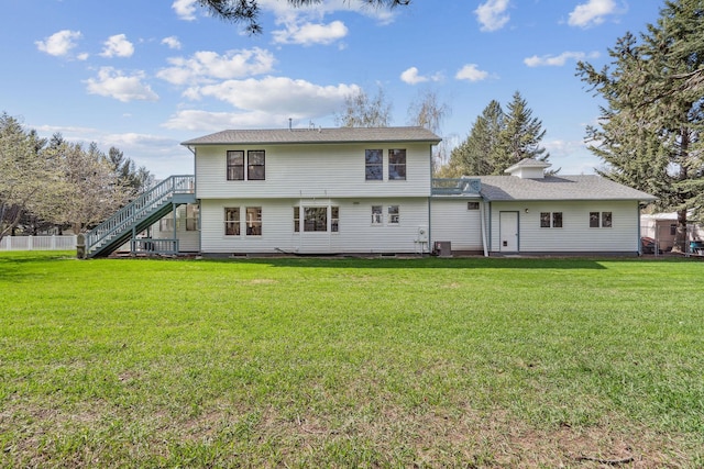 rear view of house with stairs, a yard, and crawl space