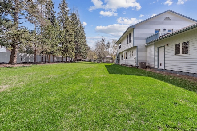view of yard with fence and central AC unit