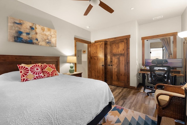 bedroom featuring ceiling fan, visible vents, wood finished floors, and a closet