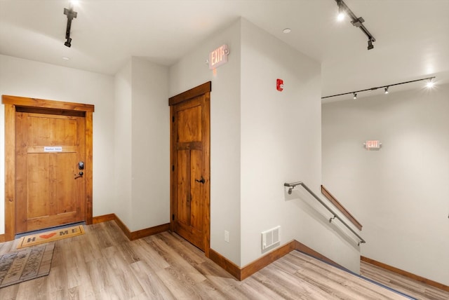 entryway featuring baseboards, track lighting, and light wood-style floors