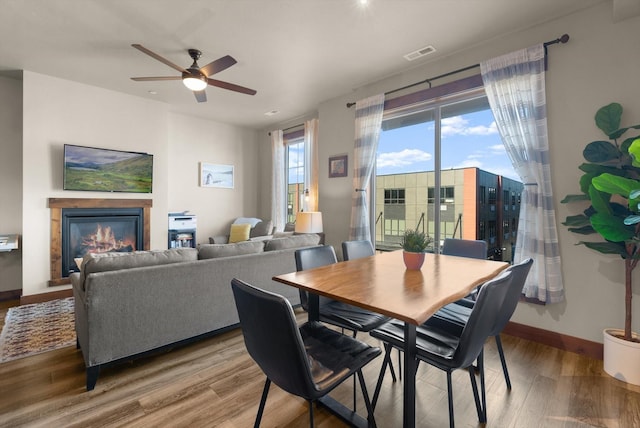519 Nucleus Ave Unit 303, Columbia Falls, MT 59912 - dining space with light wood-style flooring, ceiling fan, and a glass covered fireplace