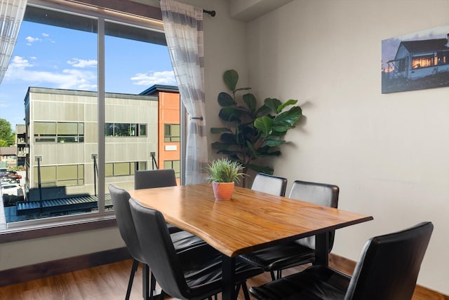 dining area with baseboards and wood finished floors