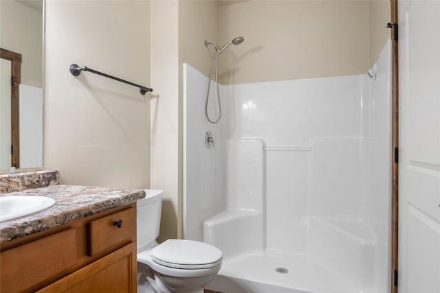 full bathroom featuring vanity, a shower, and toilet