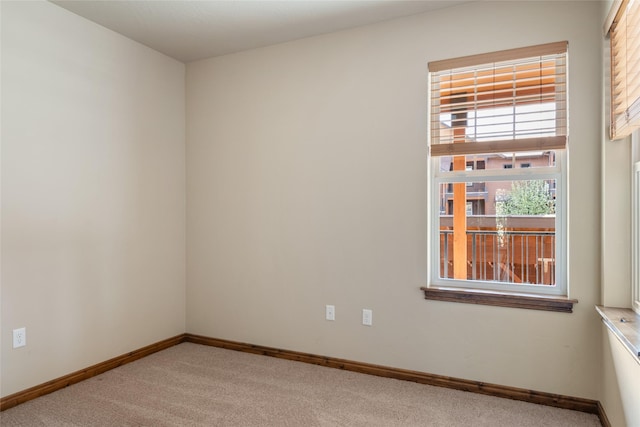 unfurnished room with carpet floors and baseboards