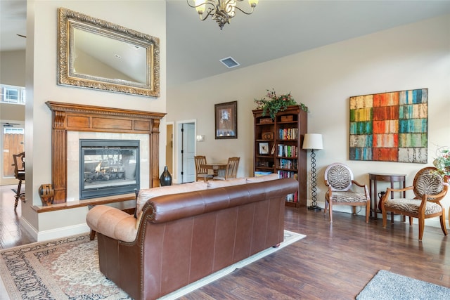 living room with visible vents, an inviting chandelier, dark wood-style flooring, baseboards, and a premium fireplace
