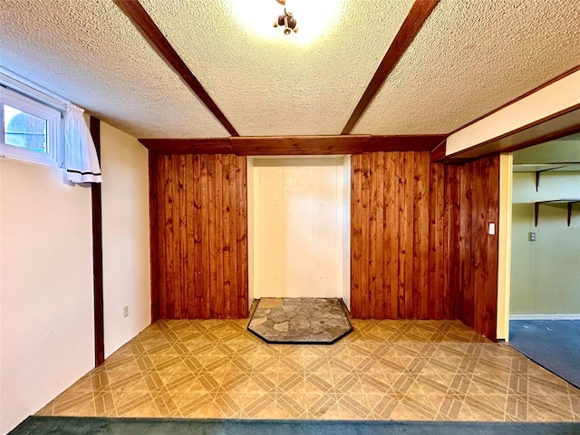 bonus room featuring wood walls and a textured ceiling
