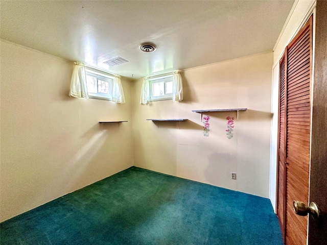 below grade area featuring dark colored carpet and visible vents